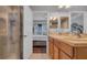 Bathroom featuring double sinks, walk in shower, and a view into the primary bedroom at 7120 Forest Mere Dr, Riverview, FL 33578
