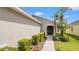 Close-up of a home's front entrance, showcasing neatly trimmed bushes lining the walkway and an arched front door at 7120 Forest Mere Dr, Riverview, FL 33578