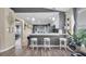 A contemporary kitchen bar with white stools, pendant lights, and gray accent walls creates a modern dining space at 7120 Forest Mere Dr, Riverview, FL 33578