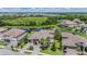 An amazing aerial view of a beautiful home featuring tile roof, lush landscaping, and a view of the water and surrounding neighborhood at 7162 Graybrook Dr, Wesley Chapel, FL 33545