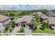 An amazing aerial view of a beautiful home featuring tile roof, lush landscaping, and a view of the water and surrounding neighborhood at 7162 Graybrook Dr, Wesley Chapel, FL 33545