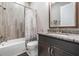 Full bath featuring granite vanity, framed mirror and shower with custom tile inlay and shower curtain at 7162 Graybrook Dr, Wesley Chapel, FL 33545