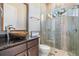 This bathroom is well-lit with a walk-in shower with a glass door and a wood vanity at 7162 Graybrook Dr, Wesley Chapel, FL 33545