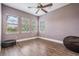 Bedroom with wood floors, ceiling fan, and three large windows providing plenty of natural light at 7162 Graybrook Dr, Wesley Chapel, FL 33545