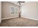 Neutral bedroom features ceiling fan, tan carpet and plantation shutters providing plenty of natural light at 7162 Graybrook Dr, Wesley Chapel, FL 33545