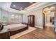 Bedroom with a tray ceiling, wood floors, and abundant natural light at 7162 Graybrook Dr, Wesley Chapel, FL 33545