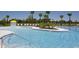 Inviting zero-entry community pool with sun loungers and playful splash fountain at 7162 Graybrook Dr, Wesley Chapel, FL 33545