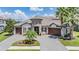 Beautiful Mediterranean style home with tile roof, stone accents, and three-car garage at 7162 Graybrook Dr, Wesley Chapel, FL 33545
