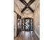 Elegant foyer with wood-look tile flooring, decorative chandelier, and rustic barn door at 7162 Graybrook Dr, Wesley Chapel, FL 33545