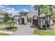 Beautiful home exterior featuring a unique turret entrance, well-manicured lawn, and spacious three car garage at 7162 Graybrook Dr, Wesley Chapel, FL 33545