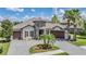 Beautiful home exterior featuring a unique turret entrance, well-manicured lawn, and spacious three car garage at 7162 Graybrook Dr, Wesley Chapel, FL 33545