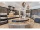 An open kitchen with granite counters, custom cabinets, stainless appliances, mosaic backsplash, and a center island at 7162 Graybrook Dr, Wesley Chapel, FL 33545