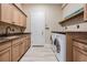 Functional laundry room with granite counters and built-in cabinets at 7162 Graybrook Dr, Wesley Chapel, FL 33545