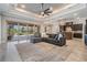 Bright living room with decorative ceiling, fan, and sliding doors leading to a screened-in pool area at 7162 Graybrook Dr, Wesley Chapel, FL 33545