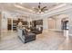 Open living room with tray ceiling, recessed lighting, and gray sofa set on beautiful tile flooring at 7162 Graybrook Dr, Wesley Chapel, FL 33545