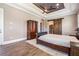 Spacious main bedroom with a tray ceiling, wood flooring, and a decorative armoire at 7162 Graybrook Dr, Wesley Chapel, FL 33545