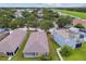 Birds-eye view of backyards with mature trees in a residential neighborhood surrounded by sidewalks and green areas at 8020 Carriage Pointe Dr, Gibsonton, FL 33534
