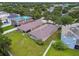 Aerial view of the grassy backyard featuring a screen enclosed porch of a home in a residential neighborhood at 8020 Carriage Pointe Dr, Gibsonton, FL 33534