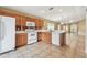 Well-lit kitchen featuring oak cabinets, white appliances, and tile flooring, perfect for culinary enthusiasts at 8020 Carriage Pointe Dr, Gibsonton, FL 33534