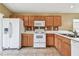 Efficient kitchen featuring tile flooring, wood cabinets and white appliances at 8020 Carriage Pointe Dr, Gibsonton, FL 33534