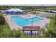 Resort-style pool area with lounge chairs, shade structures, lush landscaping, and recreational facilities nearby at 8020 Carriage Pointe Dr, Gibsonton, FL 33534