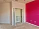 Bedroom closet featuring bifold doors, wire shelving and a pink accent wall at 824 Lantern Way, Clearwater, FL 33765