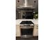 Modern kitchen island with stainless steel range, hood, and marble countertops at 824 Lantern Way, Clearwater, FL 33765
