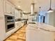 Elegant white kitchen with an island, stainless steel appliances, and a modern range hood at 824 Lantern Way, Clearwater, FL 33765