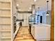 Spacious white kitchen with a center island, stainless steel appliances, and open shelving for modern appeal at 824 Lantern Way, Clearwater, FL 33765
