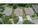 Aerial view of a well-maintained property showcasing landscaping, driveway, and the surrounding neighborhood at 8704 Winsome Way, Land O Lakes, FL 34637