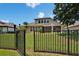 Backyard view through the black metal fence with a large green fenced yard at 8704 Winsome Way, Land O Lakes, FL 34637