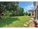 Large green fenced in backyard featuring a view of the home, patio, garden and lush green lawn at 8704 Winsome Way, Land O Lakes, FL 34637