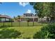Wide backyard view through the black metal fence with a lush yard and well-maintained landscaping at 8704 Winsome Way, Land O Lakes, FL 34637