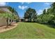 Lush backyard with a well-maintained lawn, privacy fence, and mature tree, creating a serene outdoor space at 8704 Winsome Way, Land O Lakes, FL 34637