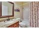 Bright bathroom featuring a granite vanity top and shower with patterned curtain at 8704 Winsome Way, Land O Lakes, FL 34637