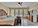 Primary bedroom suite with shuttered windows, stylish decor, and wood floors at 8704 Winsome Way, Land O Lakes, FL 34637