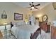 Bedroom with a ceiling fan, hardwood floors, two dressers, and neutral colors at 8704 Winsome Way, Land O Lakes, FL 34637
