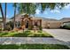 Charming home with stone accents, landscaped yard, three-car garage, and American flag on a sunny day at 8704 Winsome Way, Land O Lakes, FL 34637