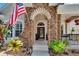 Close-up of the covered porch area, showcasing stone detailing, front door, and manicured landscaping at 8704 Winsome Way, Land O Lakes, FL 34637