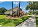 View of the house exterior with palm trees, well-maintained lawn, and an inviting stone-accented entrance at 8704 Winsome Way, Land O Lakes, FL 34637