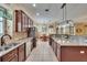 Open kitchen with granite counters, stainless appliances, and island with stone accent at 8704 Winsome Way, Land O Lakes, FL 34637