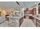 Open-concept kitchen with stainless appliances, granite countertops, and a stone-accented island at 8704 Winsome Way, Land O Lakes, FL 34637