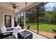 Enclosed patio with outdoor seating and lush backyard views at 8704 Winsome Way, Land O Lakes, FL 34637