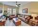Comfortable living room features two leather sofas, neutral decor, and a ceiling fan at 8704 Winsome Way, Land O Lakes, FL 34637