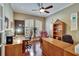 Inviting home office features wood floors, built-in shelving, dual desks, and charming shuttered windows at 8704 Winsome Way, Land O Lakes, FL 34637