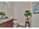 This powder room features a wood cabinet with granite top, faucet, toilet and a decorative potted plant at 8704 Winsome Way, Land O Lakes, FL 34637