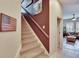 Carpeted staircase with stained wood handrail and freshly painted accent wall at 8704 Winsome Way, Land O Lakes, FL 34637