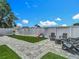 Backyard featuring artificial turf, a paver patio, outdoor seating, and a secure white fence at 8717 Persea Ct, Trinity, FL 34655