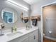 Contemporary bathroom featuring a double sink vanity, stylish mirrors, and a glass-enclosed shower at 8717 Persea Ct, Trinity, FL 34655