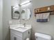 Bathroom with vanity, sink and a round mirror, well-lit and modern at 8717 Persea Ct, Trinity, FL 34655